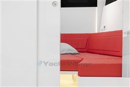 Red seating area inside 2025 VanDutch 48 yacht, featuring modern design and cozy ambiance.