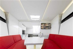 Luxurious interior of 2025 VanDutch 48 yacht with red seating and modern decor.