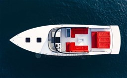 Top view of a 2025 VanDutch 48 yacht with red seating on blue water.