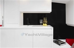 Modern VanDutch 48 yacht interior with sleek white cabinetry, black accents, and champagne bottles.