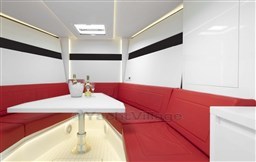 Luxurious interior of 2025 VanDutch 48 yacht with red seating and modern white table.