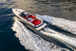 2025 VanDutch 48 yacht cruising on water, featuring sleek design and red seating.