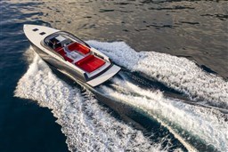 2025 VanDutch 48 luxury yacht cruising on open water, featuring sleek design and red seating.