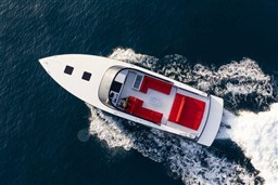2025 VanDutch 48 yacht cruising on open water, featuring sleek design and red seating.