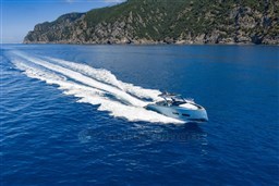 2026 Pardo Yachts 43 cruising on blue ocean near rocky coastline.
