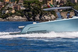 2026 Pardo Yachts 43 cruising on blue waters near a scenic coastal town.