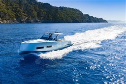 2026 Pardo Yachts 43 cruising on clear blue waters near a rocky coastline.