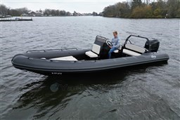 2021 Infanta 750 boat on a calm lake with a person at the helm.