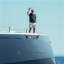 Man waving on Pardo Yachts GT75, 2025 model, under clear blue sky.