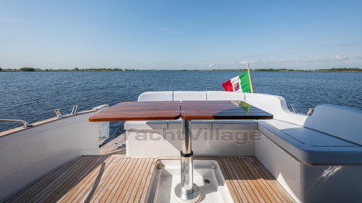 2024 Apreamare GOZZO 38 CABIN yacht deck with seating and table, overlooking serene water.