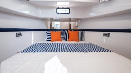 2024 Apreamare GOZZO 38 CABIN interior with stylish bedding and vibrant cushions.