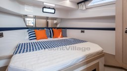 Luxurious cabin interior of 2024 Apreamare GOZZO 38, featuring stylish bedding and vibrant cushions.