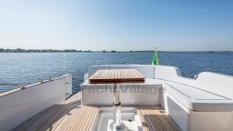 2024 Apreamare GOZZO 38 CABIN yacht deck with seating and table, overlooking serene water.