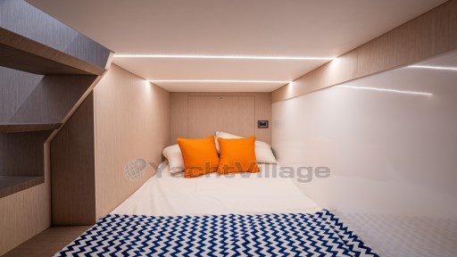 2024 Apreamare GOZZO 38 CABIN interior with cozy bed, orange pillows, and modern lighting.