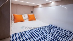 2024 Apreamare GOZZO 38 CABIN interior with cozy bed, orange pillows, and zigzag blanket.