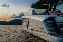 2024 Wider Wilder 60 yacht on serene water at sunset.