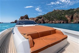 Luxurious 2024 Wider Wilder 60 yacht with sunbed, cruising near rocky coastline.