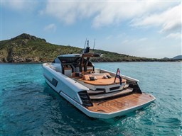 2024 Wider Wilder 60 yacht cruising in clear blue waters near a scenic coastline.