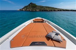 2024 Wider Wilder 60 yacht with sunbathing deck, cushions, and scenic island view.