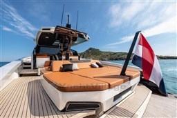 2024 Wider Wilder 60 yacht with sun deck and flag, cruising in clear waters.