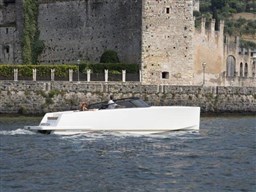 VanDutch 32 yacht cruising near historic stone building, 2025 model.