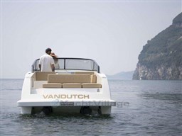 VanDutch 32 yacht cruising near a rocky coastline, 2025 model.