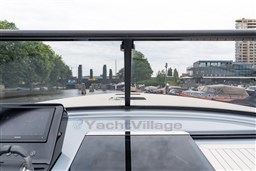 2024 VanDutch 40 yacht cockpit view, featuring modern navigation equipment and a scenic waterfront backdrop.