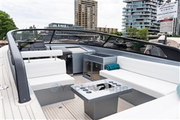 2024 VanDutch 40 yacht interior with sleek seating, modern design, and cityscape backdrop.