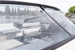 2024 VanDutch 40 yacht interior with sleek design and modern steering, docked by a serene lake.