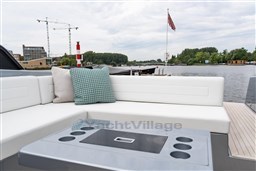 2024 VanDutch 40 yacht interior with white seating and scenic waterfront view.