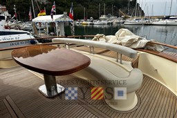 Luxury Fratelli Aprea 50 yacht deck with elegant seating and wooden table, docked in marina.