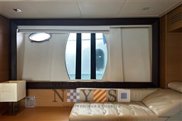 Luxurious interior of 2009 Pershing 72 yacht with leather seating and large window.