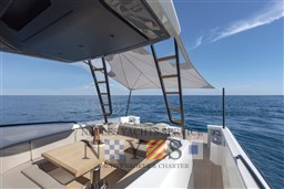 2022 Bluegame BG 42 yacht deck with seating, table, and ocean view.