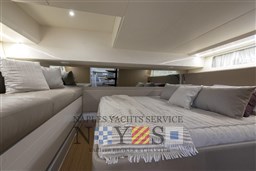 Luxurious interior of 2022 Bluegame BG 42 yacht with cozy bedding and seating.